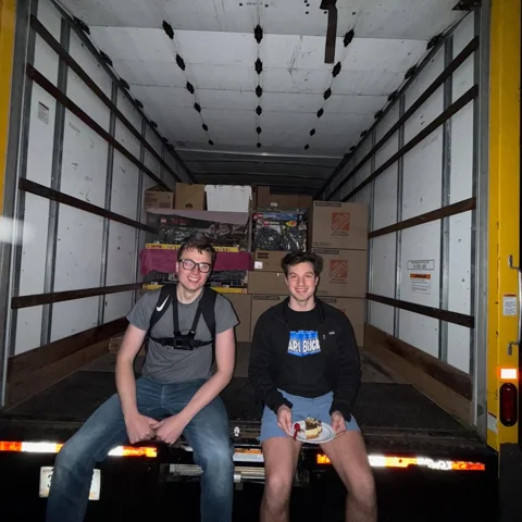 The Wapi team sitting at the back of the truck with the California LEGO collection packed behind them