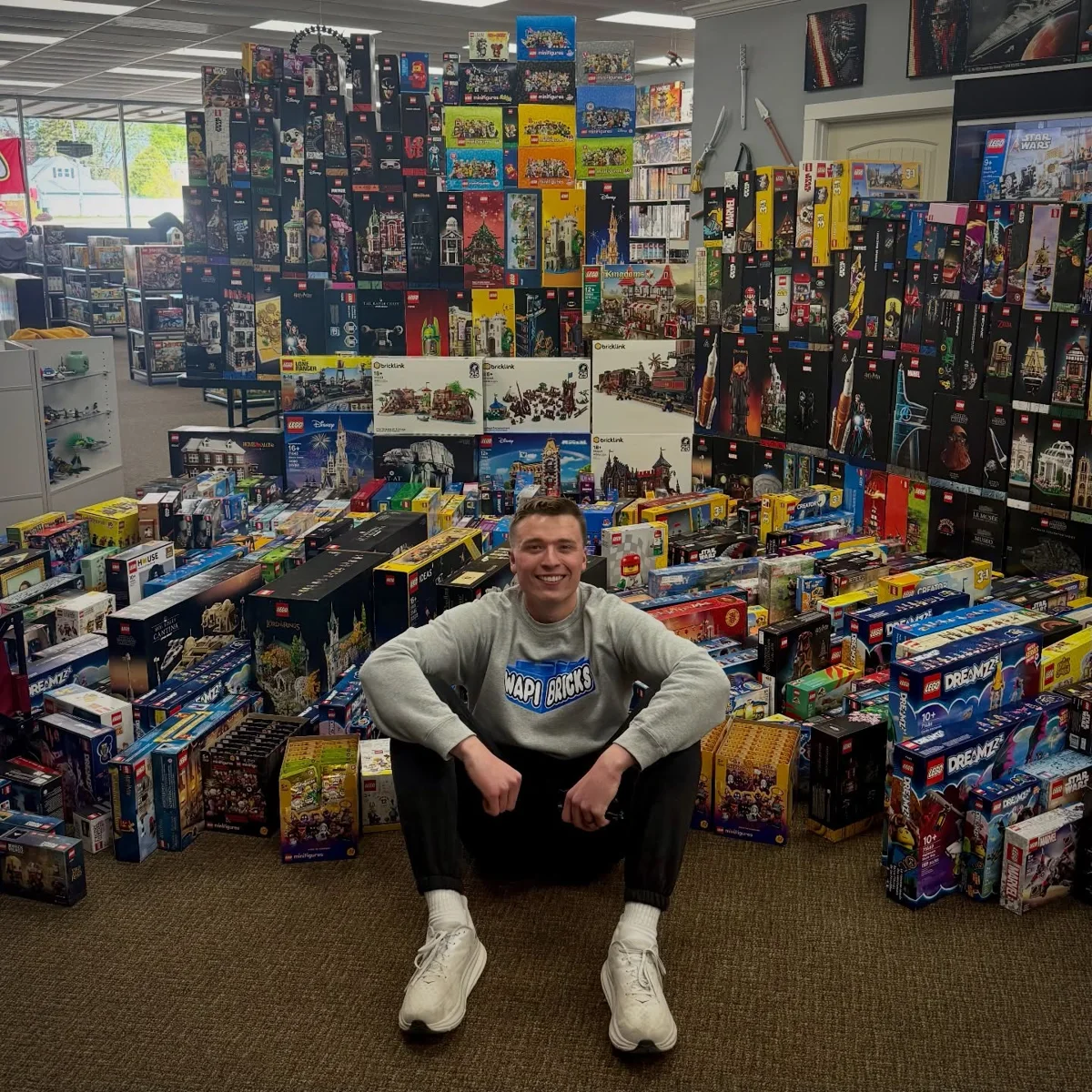 Zach seated in front of the wall of LEGO sets from Michael’s California collection